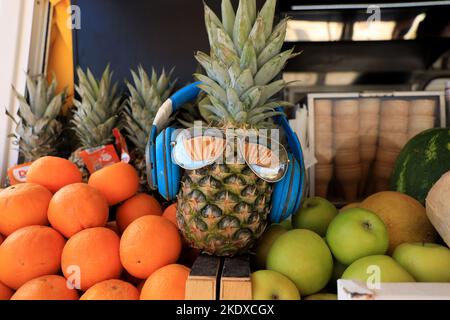 Larnaca, Chypre. 24th mai 2022. Ananas à un jus de fruit sable portant des écouteurs et des nuances. La République de Chypre se trouve à un carrefour historique et culturel entre l'Europe et l'Asie. Ses principales villes, la capitale de Nicosie, Limassol, Famagusta et Paphos, ont absorbé les influences de générations de conquérants, de pèlerins et de voyageurs et ont un air à la fois cosmopolite et provincial. Aujourd'hui, Chypre est une destination touristique populaire pour les visiteurs d'Europe, favorisée par les jeunes mariés (Credit image: © Ruaridh Stewart/ZUMA Press Wire) Banque D'Images