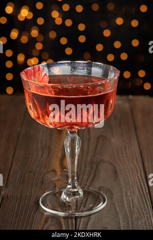 Cocktail Negroni classique dans un verre d'élégance avec fleur sur fond noir Banque D'Images