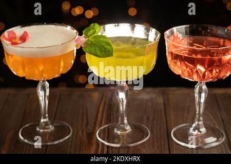 Assortiment de cocktails servi sur fond sombre dans une discothèque au bar, espace pour le texte. Menu de boissons classiques Banque D'Images