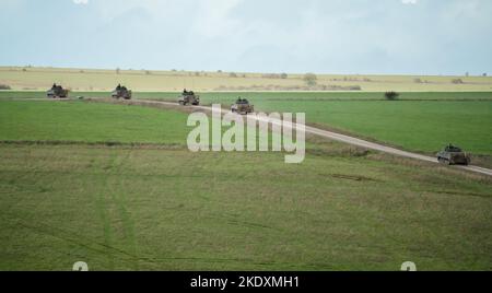 Une unité de l'armée britannique Warrior FV510 véhicules de combat d'infanterie roulant le long d'une piste de boue, en action sur un exercice militaire, Wiltshire, Royaume-Uni Banque D'Images