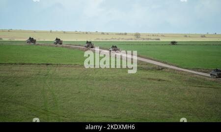 Une unité de l'armée britannique Warrior FV510 véhicules de combat d'infanterie roulant le long d'une piste de boue, en action sur un exercice militaire, Wiltshire, Royaume-Uni Banque D'Images