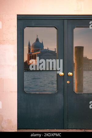 Célèbre église il Redentore située sur l'île Giudecca près de l'eau de canal ondulant derrière la porte en soirée à Venise, Italie Banque D'Images