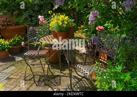 Chaises et table en métal dans le jardin à Whichford Pottery , Whichford,Cotswolds,Angleterre Banque D'Images