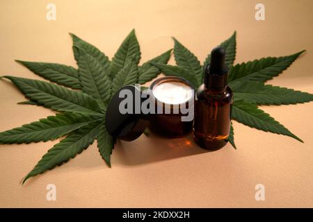 Une maquette pour votre produit cosmétique de soin du visage et du corps à base de cannabis médical. Sérum ou huile et crème sur fond clair. Copier l'espace. Concept de santé et de bien-être. Banque D'Images
