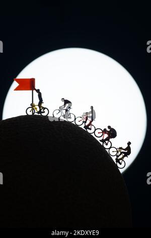 Jouets miniatures Silhouette - cycliste approchant de la ligne d'arrivée, concept de célébration. Banque D'Images