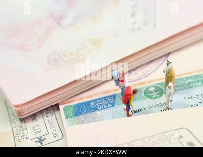 Concept de jouet miniature de deux Arabes accueillant des invités étrangers avec visa d'Arabie Saoudite comme arrière-plan. Banque D'Images