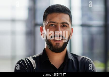 jeune homme d'affaires souriant au bureau avec ses bras croisés Banque D'Images
