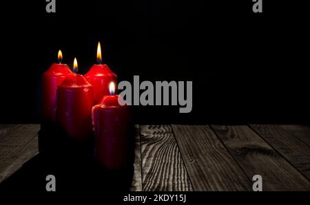 Quatre bougies à thème de l'AVENT sur une table en bois sombre. Banque D'Images