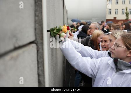 Berlin, Allemagne 09 novembre 2022, Berlin, Berlin/Potsdam: Des étudiants d'Allemagne, de France et de Norvège collent des roses dans le mur de Vorderland lors de la commémoration centrale du 33rd anniversaire de la chute du mur de Berlin au Mémorial du mur de Berlin. Photo: Joerg Carstensen/dpa - ATTENTION: Seulement pour une utilisation éditoriale en format complet et seulement dans le cadre d'une couverture de la commémoration nommée et seulement avec la mention complète du crédit ci-dessus Credit: dpa Picture Alliance/Alay Live News Banque D'Images