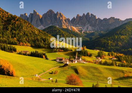 Une image d'un coucher de soleil d'automne à la célèbre église et village de Santa Maddalena en face des sommets de Geisler ou Odle Dolomites à Val di Banque D'Images