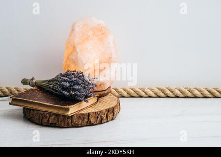 Utiliser une corde de jute comme garniture de plancher, élément de conception de la maison de boho. Sol blanc de la salle de séjour avec garniture en corde de jute, plateau à disques en bois, livre vintage et lavande séchée. Banque D'Images