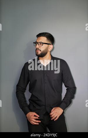 Jeune homme d'affaires élégant vêtu d'une chemise en Jean décontractée avec montre intelligente au poignet Banque D'Images