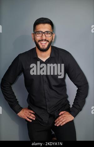 Jeune homme d'affaires élégant vêtu d'une chemise en Jean décontractée avec montre intelligente au poignet Banque D'Images