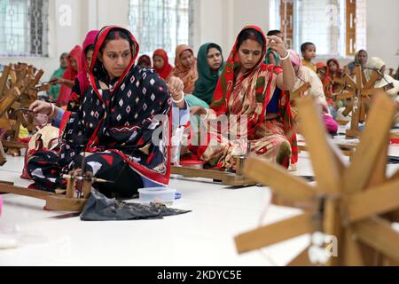 Les travailleurs font tourner le fil de coton pour fabriquer des vêtements de mousseline traditionnels dans un atelier à Narayanganj. Avec ses roues tournants en bois et ses métiers à tisser dessinés à la main, le Bangladesh ressuscite minutieusement un tissu autrefois porté par Marie-Antoinette et Jane Austen, mais longtemps considéré comme perdu à jamais dans l'histoire. -Aller avec 'Bangladesh-Fashion-Muslin'. Sur 8 novembre 2022 à Narayanganj, Dhaka, Bangladesh. Photo de Habibur Rahman/ABACAPRESS.COM Banque D'Images