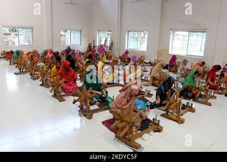 Les travailleurs font tourner le fil de coton pour fabriquer des vêtements de mousseline traditionnels dans un atelier à Narayanganj. Avec ses roues tournants en bois et ses métiers à tisser dessinés à la main, le Bangladesh ressuscite minutieusement un tissu autrefois porté par Marie-Antoinette et Jane Austen, mais longtemps considéré comme perdu à jamais dans l'histoire. -Aller avec 'Bangladesh-Fashion-Muslin'. Sur 8 novembre 2022 à Narayanganj, Dhaka, Bangladesh. Photo de Habibur Rahman/ABACAPRESS.COM Banque D'Images
