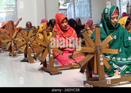 Les travailleurs font tourner le fil de coton pour fabriquer des vêtements de mousseline traditionnels dans un atelier à Narayanganj. Avec ses roues tournants en bois et ses métiers à tisser dessinés à la main, le Bangladesh ressuscite minutieusement un tissu autrefois porté par Marie-Antoinette et Jane Austen, mais longtemps considéré comme perdu à jamais dans l'histoire. -Aller avec 'Bangladesh-Fashion-Muslin'. Sur 8 novembre 2022 à Narayanganj, Dhaka, Bangladesh. Photo de Habibur Rahman/ABACAPRESS.COM Banque D'Images