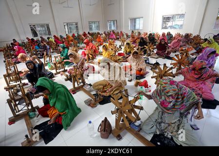 Les travailleurs font tourner le fil de coton pour fabriquer des vêtements de mousseline traditionnels dans un atelier à Narayanganj. Avec ses roues tournants en bois et ses métiers à tisser dessinés à la main, le Bangladesh ressuscite minutieusement un tissu autrefois porté par Marie-Antoinette et Jane Austen, mais longtemps considéré comme perdu à jamais dans l'histoire. -Aller avec 'Bangladesh-Fashion-Muslin'. Sur 8 novembre 2022 à Narayanganj, Dhaka, Bangladesh. Photo de Habibur Rahman/ABACAPRESS.COM Banque D'Images