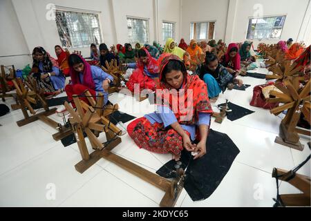 Les travailleurs font tourner le fil de coton pour fabriquer des vêtements de mousseline traditionnels dans un atelier à Narayanganj. Avec ses roues tournants en bois et ses métiers à tisser dessinés à la main, le Bangladesh ressuscite minutieusement un tissu autrefois porté par Marie-Antoinette et Jane Austen, mais longtemps considéré comme perdu à jamais dans l'histoire. -Aller avec 'Bangladesh-Fashion-Muslin'. Sur 8 novembre 2022 à Narayanganj, Dhaka, Bangladesh. Photo de Habibur Rahman/ABACAPRESS.COM Banque D'Images