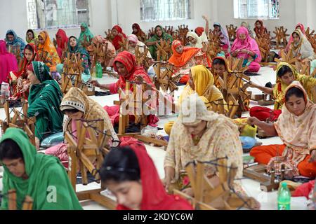 Les travailleurs font tourner le fil de coton pour fabriquer des vêtements de mousseline traditionnels dans un atelier à Narayanganj. Avec ses roues tournants en bois et ses métiers à tisser dessinés à la main, le Bangladesh ressuscite minutieusement un tissu autrefois porté par Marie-Antoinette et Jane Austen, mais longtemps considéré comme perdu à jamais dans l'histoire. -Aller avec 'Bangladesh-Fashion-Muslin'. Sur 8 novembre 2022 à Narayanganj, Dhaka, Bangladesh. Photo de Habibur Rahman/ABACAPRESS.COM Banque D'Images
