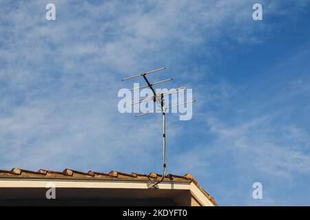 Photo à angle bas d'une antenne TV sur le toit d'une maison sous un ciel bleu Banque D'Images