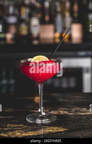 Un gros plan vertical d'un cocktail cosmopolite dans un verre dans un café Banque D'Images