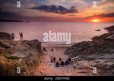 Vacanciers profitant d'un coucher de soleil spectaculaire sur la baie de Fistral à Newquay en Cornouailles au Royaume-Uni en Europe. Banque D'Images