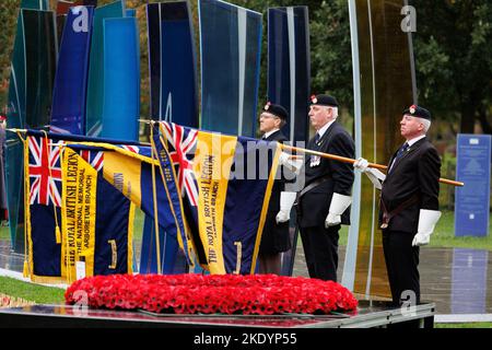 Le dévouement du champ de pavot de mémoire à l'Arboretum National Memorial à Staffordshire, Royaume-Uni. Les porteurs de drapeau de la Légion britannique photographiés au service. Banque D'Images