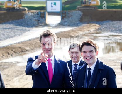 09 novembre 2022, Rhénanie-du-Nord-Westphalie, Voerde : le ministre de la Rhénanie-du-Nord-Westphalie, le président de la CDU, Frank Dudda, président du Conseil de surveillance de l'Emschergenossenschaft, et Uli Paetzel, président du Conseil de l'Emschergenossenschaft, inaugurent la nouvelle bouche de l'Emscher dans le Rhin. Jusqu'à présent, l'eau de l'Emscher plongea dans le Rhin à une structure d'estuaire de Dinslaken à une profondeur d'environ cinq mètres. Cela a empêché les poissons de nager en amont. Avec la renaturation de l'Emscher, la différence de hauteur est maintenant compensée doucement dans une plaine inondable Banque D'Images