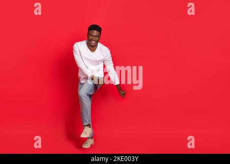 Photo pleine de rires pleines de joie hommes danse sans souci flirtant avec petite amie isolée sur fond rouge Banque D'Images