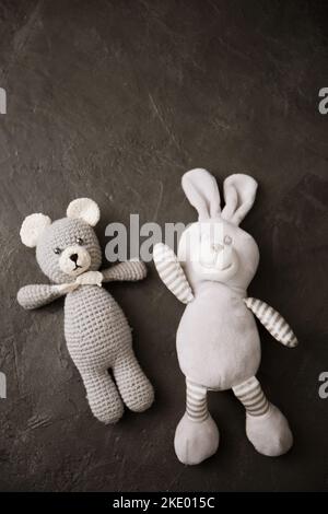 Ours crocheté de style amigurumi et lapin sur fond gris Banque D'Images