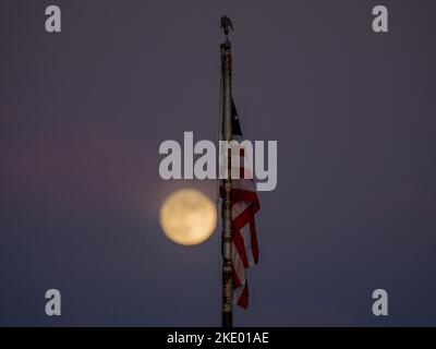 Une pleine lune brille d'une teinte jaune lorsqu'elle s'élève au-dessus de Phoenix Arizona lors d'une nuit d'automne Banque D'Images