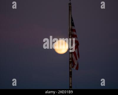 Une pleine lune brille d'une teinte jaune lorsqu'elle s'élève au-dessus de Phoenix Arizona lors d'une nuit d'automne Banque D'Images