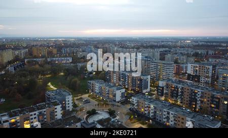 Une vue aérienne d'un panorama de la ville de Wroclaw, Pologne, pendant le coucher du soleil, avec des feux de rue allumés, un parc et un rond-point en arrière-plan Banque D'Images