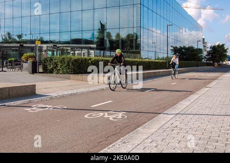 Helsinki, Finlande - 22 août 2022 : les cyclistes en casques de protection longent une piste cyclable dans le centre-ville, sur la place Kansalaistori Banque D'Images