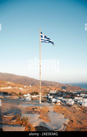 Vue aérienne verticale d'un drapeau grec sur une colline qui domine l'île de Tinos Banque D'Images