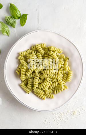 Pâtes fusilli, avec pesto alla genovese dans une assiette. Certains ingrédients sont le basilic, le parmesan, les pignons et l'huile d'olive. Banque D'Images