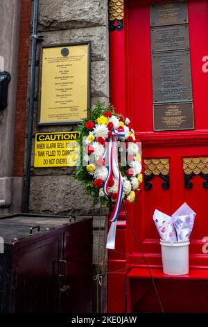 Souvenir de 9/11 avec des fleurs devant la liste des pompiers perdus sur 9/11 Squad 18 Firehouse 10th St, Greenwich Village, New York City, NY, Banque D'Images