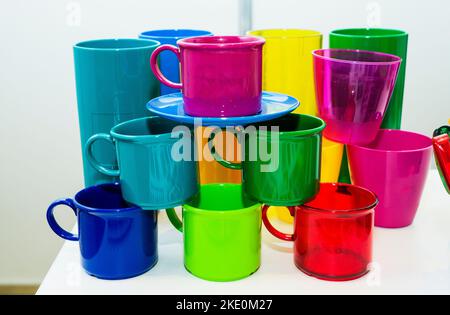 Mugs en plastique coloré fabriqués dans des matériaux écologiques sur fond blanc. Concept de protection de l'environnement. Banque D'Images