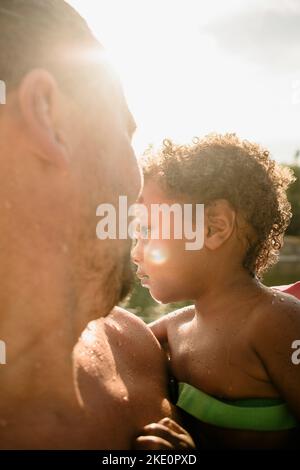 Père transportant son fils le jour ensoleillé pendant les vacances Banque D'Images