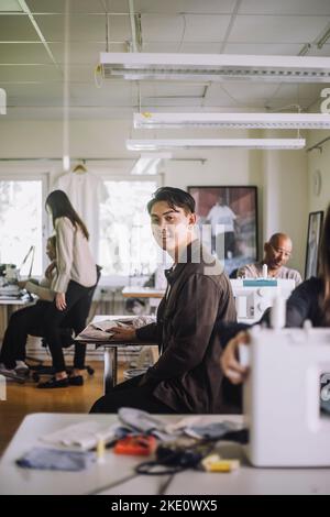 Vue latérale portrait d'un professionnel du design masculin assis à l'atelier Banque D'Images