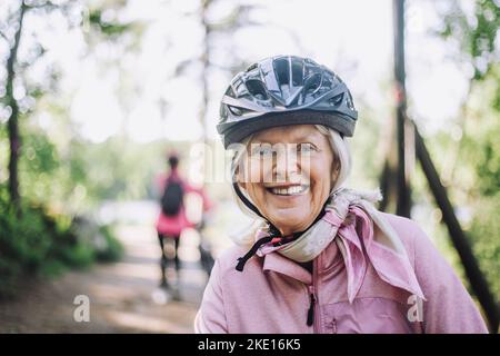 Portrait d'une femme âgée heureuse portant un casque de cyclisme Banque D'Images