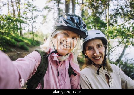 Portrait de femmes âgées heureuses prenant un selfie portant un casque de cyclisme Banque D'Images