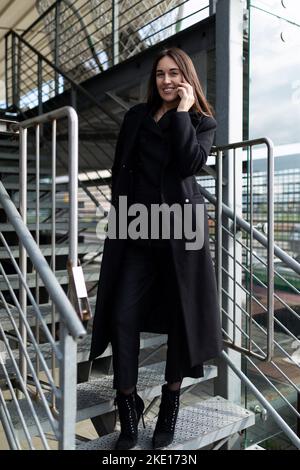 une femme analyste de private equity en entreprise s'attire sur un téléphone mobile de l'extérieur Banque D'Images