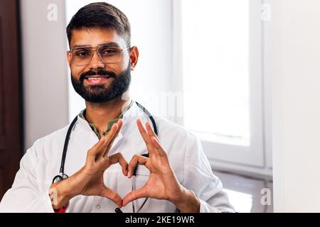 étudiant en médecine hispanique sous un manteau blanc avec stéthoscope en clinique Banque D'Images
