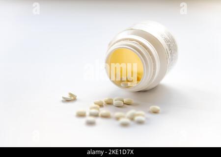 Une bouteille ouverte de comprimés analgésiques isolés sur fond blanc. Banque D'Images