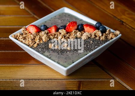 Un bol de granola avec du yogourt grec frais naturel non sucré, des fruits et des graines de chia Banque D'Images