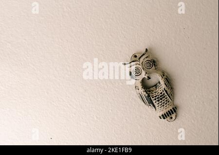 Masque hibou sur un fond de mur de brique blanche Banque D'Images