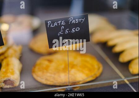 Tarte et pasties à vendre dans une boulangerie, mains tenant une tarte Banque D'Images