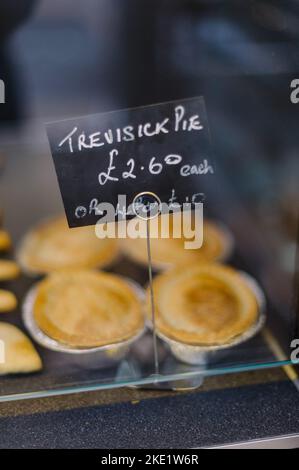 Tarte et pasties à vendre dans une boulangerie, mains tenant une tarte Banque D'Images