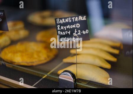 Tarte et pasties à vendre dans une boulangerie, mains tenant une tarte Banque D'Images